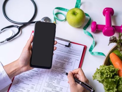 Main d'une personne qui tient un téléphone pour les consultations externes et téléphoniques